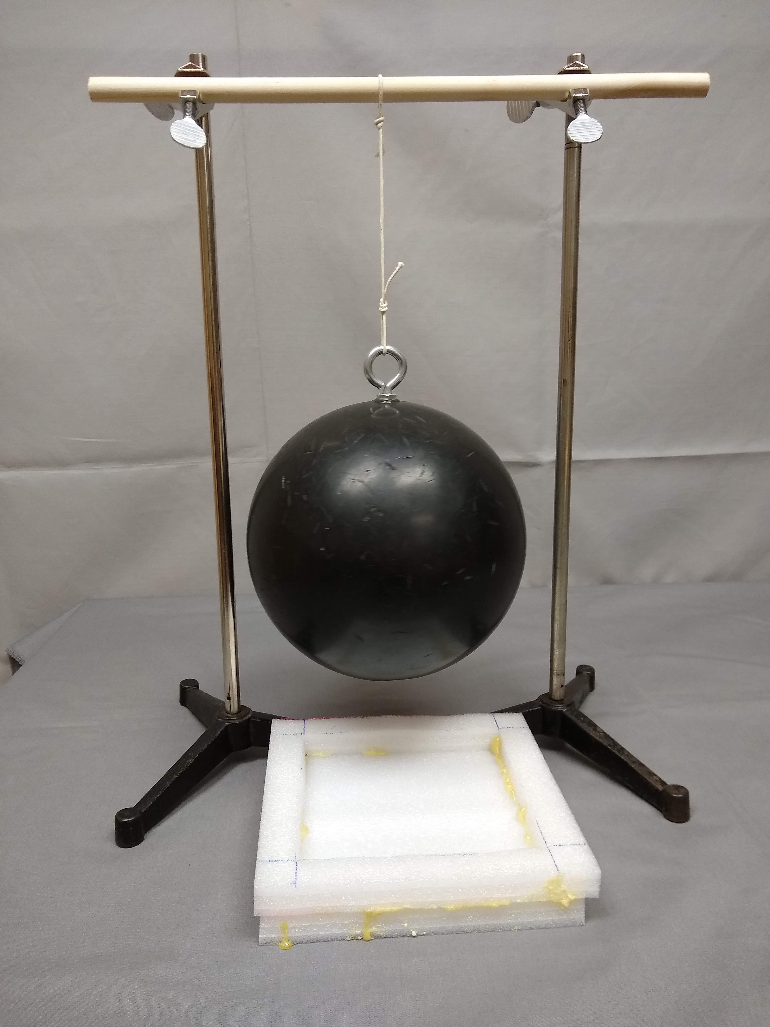 Bowling ball held suspended by string