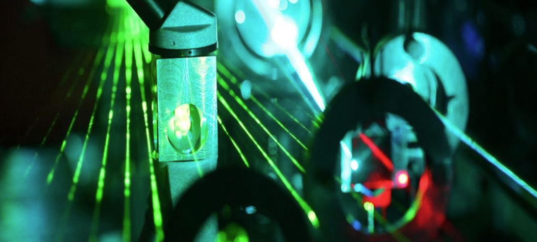 A bunch of parallel green lasers shining through instrumentation