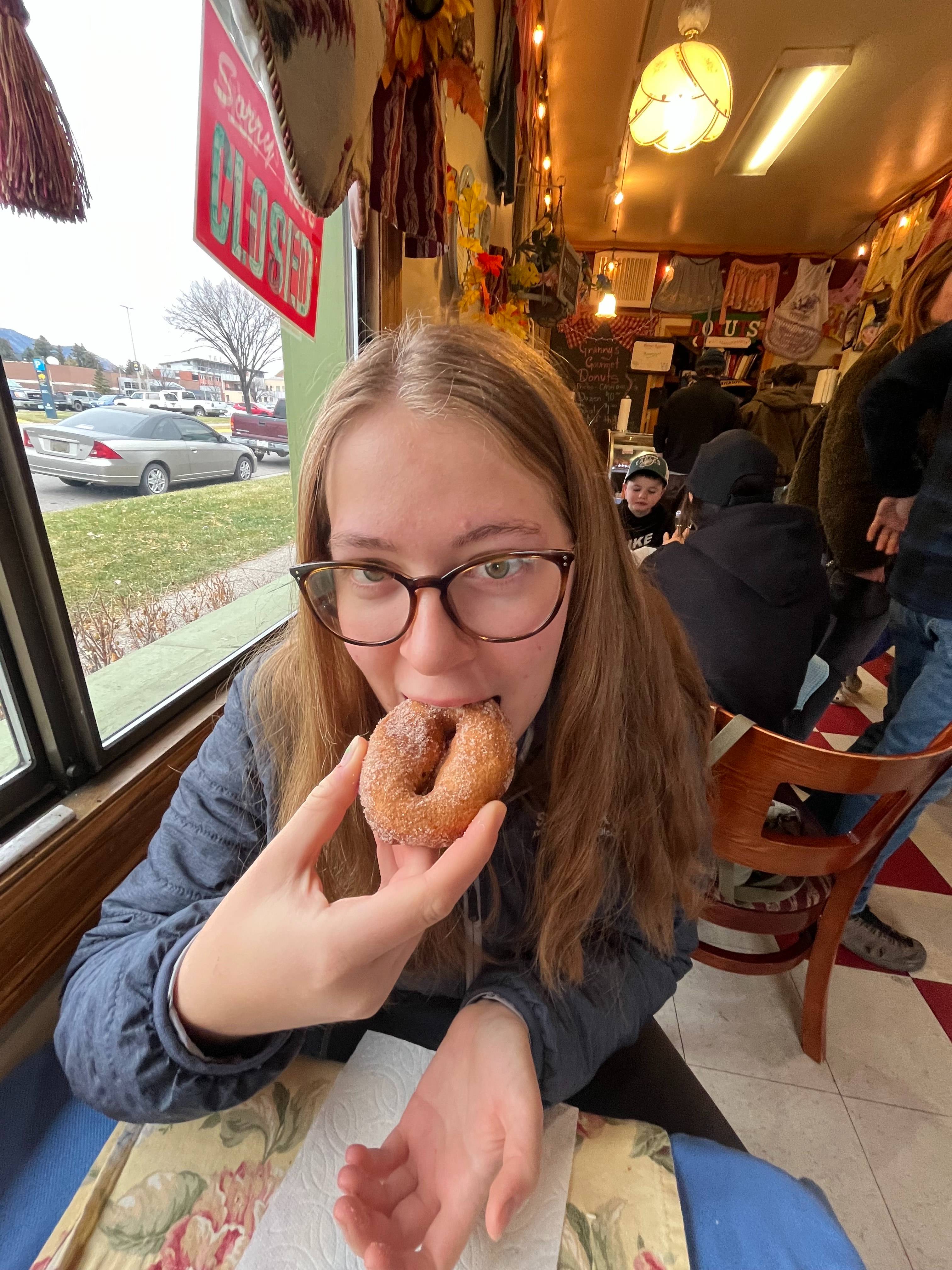 Danielle eating a donut in a restaurant